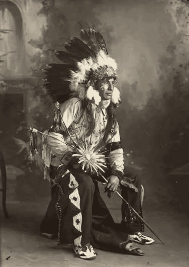 Ptehé Wóptuȟ'a — Encouraging Bear — in ceremonial dress, early 20th century.